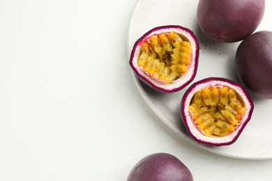 Photo of Fresh passion fruits on white table, space for text