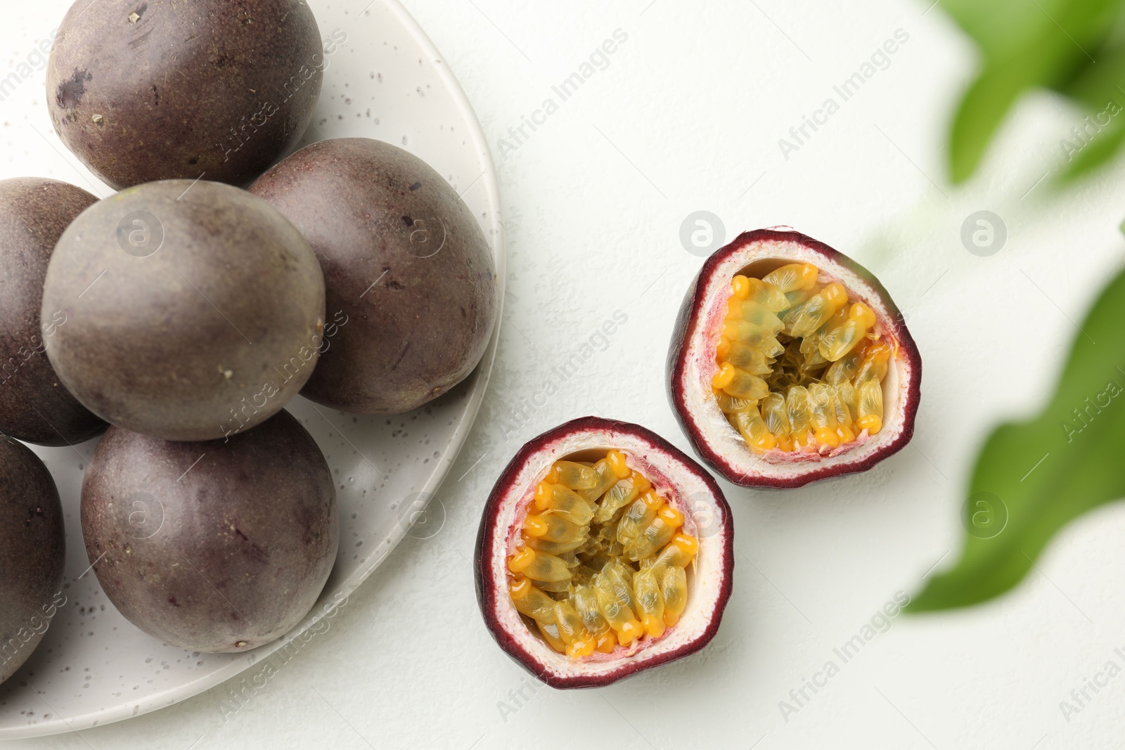 Fresh passion fruits on white table, above view. Whole and cut Photo of Fresh passion fruits on white table, above view. Whole and cut