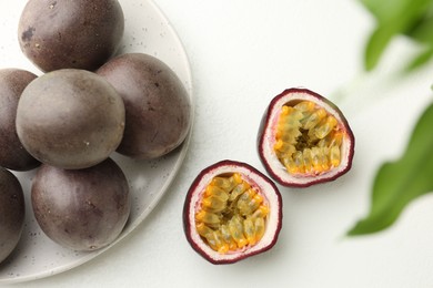 Photo of Fresh passion fruits on white table, above view. Whole and cut