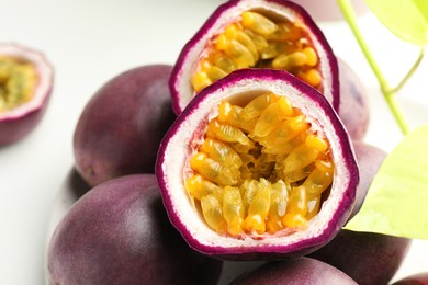 Photo of Fresh passion fruits on white table, closeup