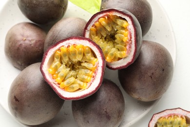 Photo of Fresh passion fruits on white table, closeup