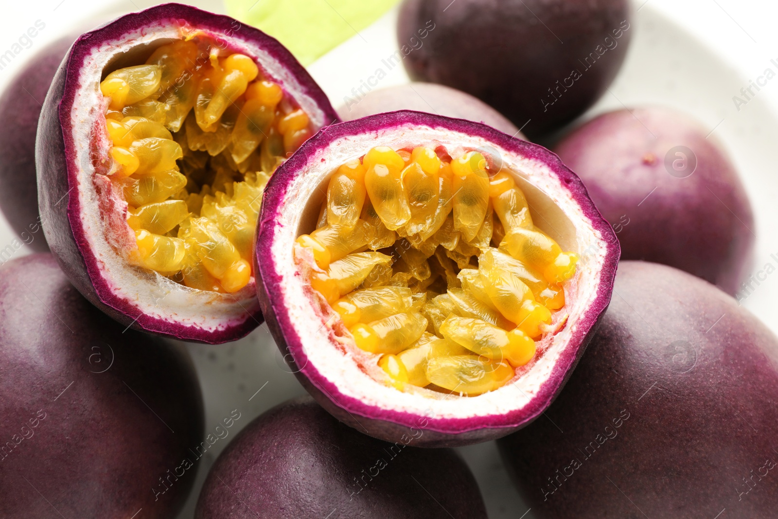 Fresh passion fruits on table, closeup. Whole and cut Photo of Fresh passion fruits on table, closeup. Whole and cut