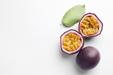 Photo of Fresh passion fruits with green leaf on white background, flat lay. Space for text