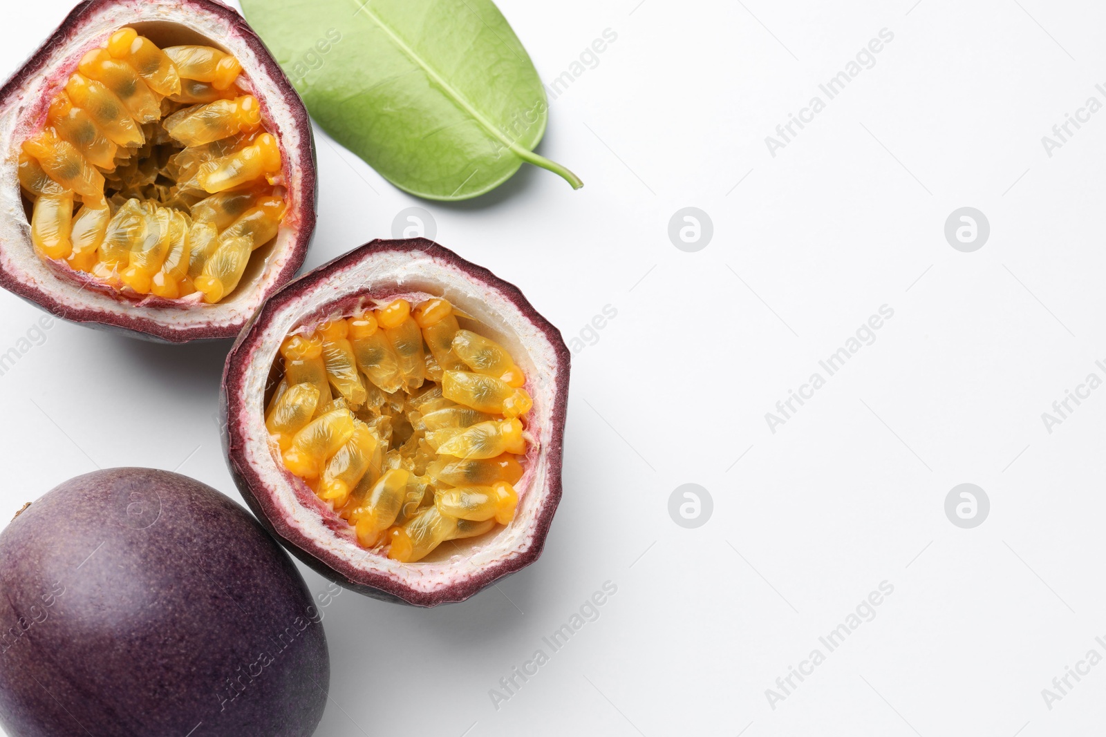 Fresh passion fruits with green leaf on white background, above view. Space for text Photo of Fresh passion fruits with green leaf on white background, above view. Space for text