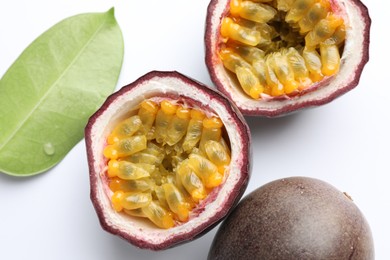 Photo of Fresh passion fruits with green leaf on white background, closeup