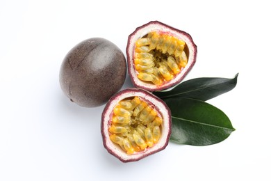 Photo of Fresh passion fruits with green leaves on white background, top view