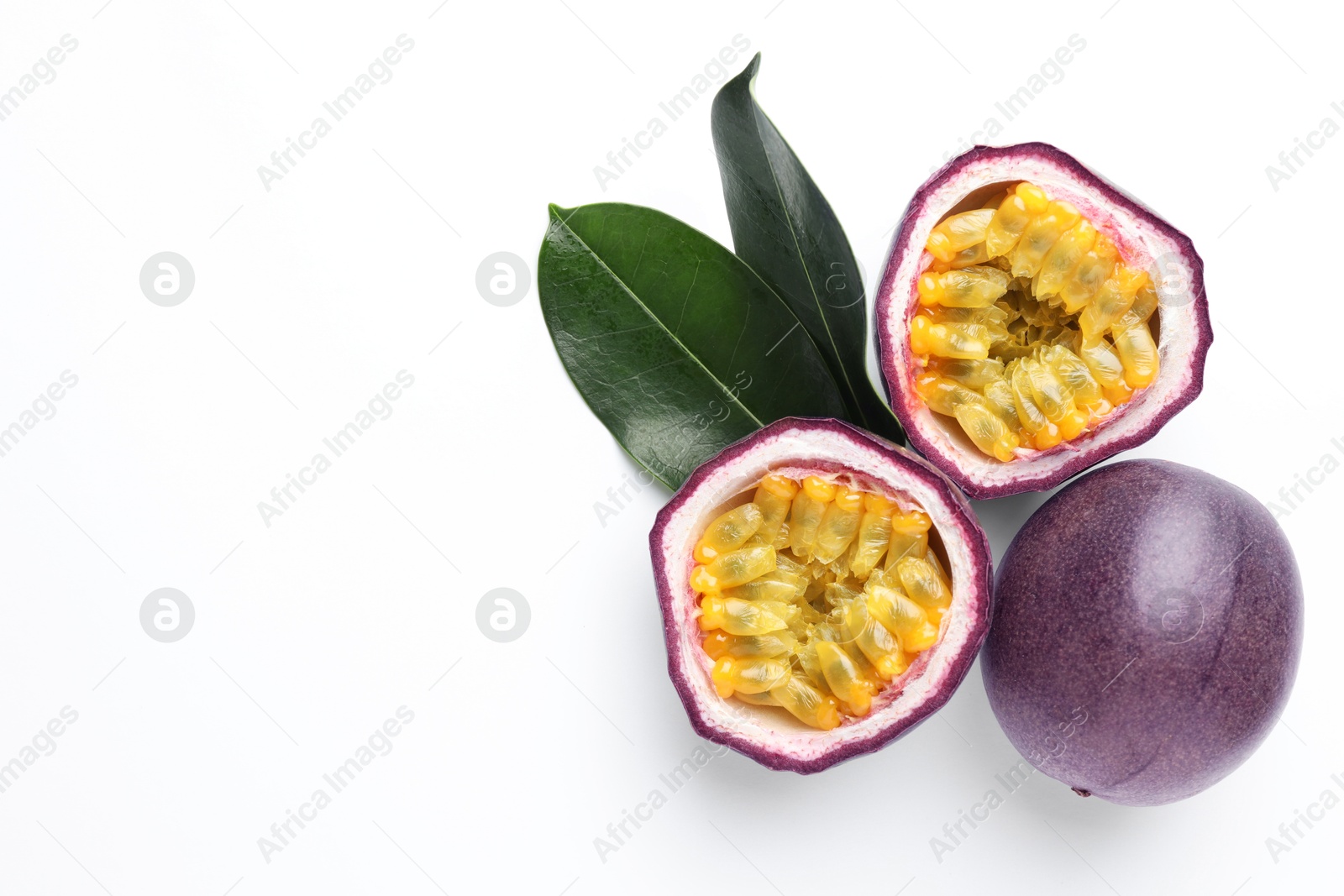 Fresh passion fruits with green leaves on white background, top view. Space for text Photo of Fresh passion fruits with green leaves on white background, top view. Space for text