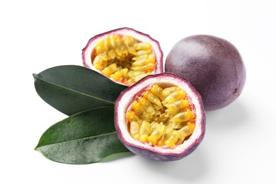 Photo of Fresh passion fruits with green leaves on white background, closeup