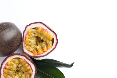 Photo of Fresh passion fruits with green leaves on white background, flat lay. Space for text