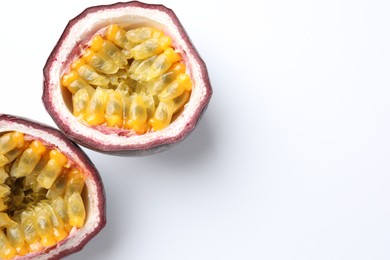 Photo of Halves of fresh passion fruit on white background, closeup. Space for text