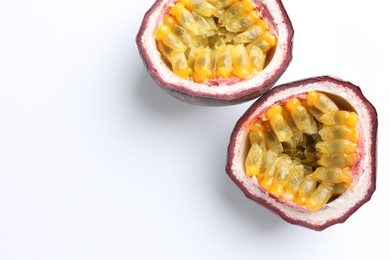 Photo of Halves of fresh passion fruit on white background, closeup. Space for text