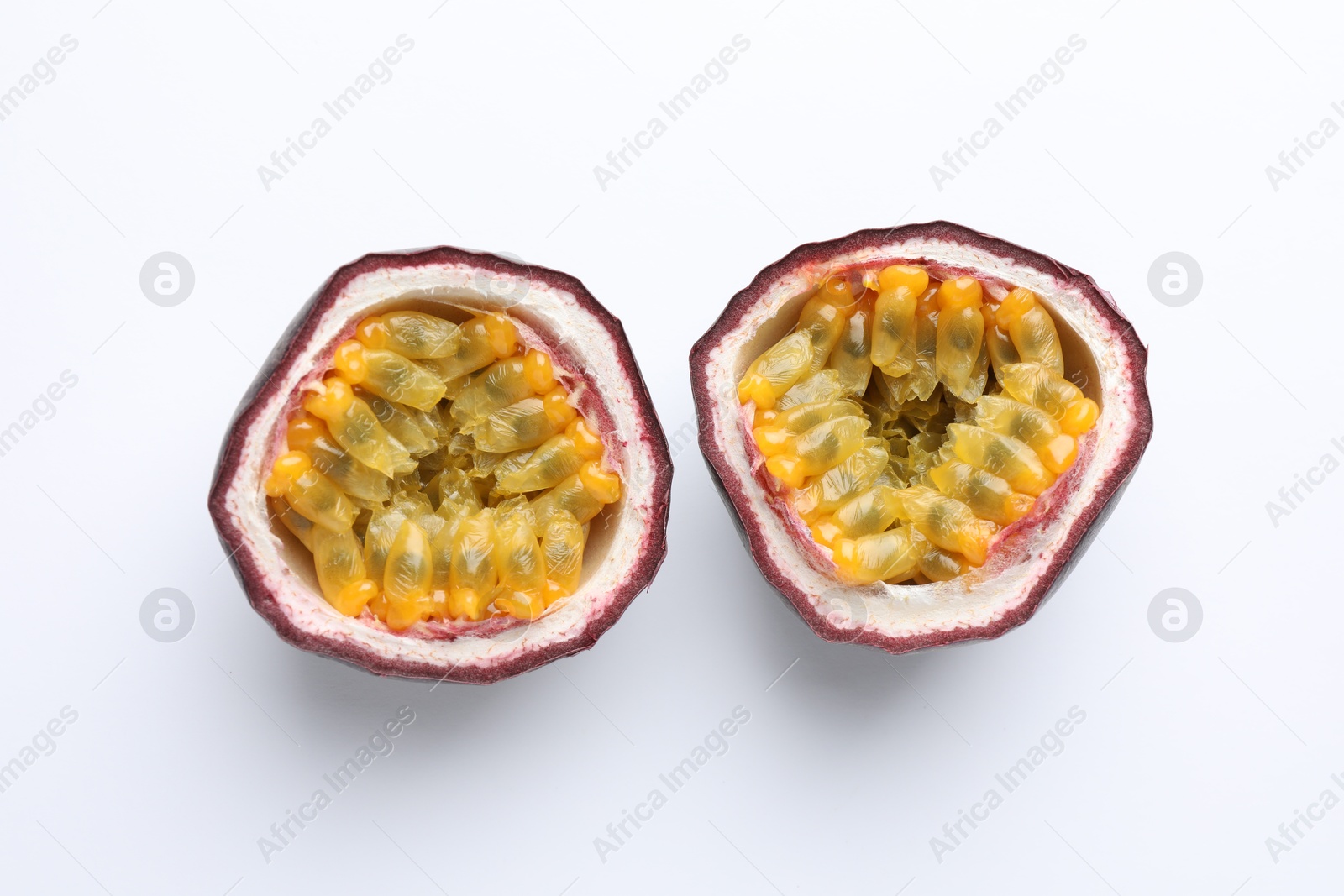 Photo of Halves of fresh passion fruit on white background, above view