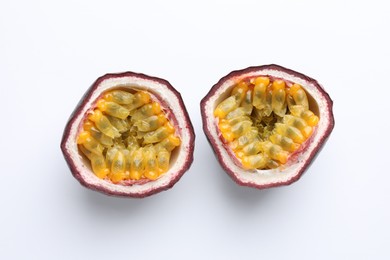 Photo of Halves of fresh passion fruit on white background, above view