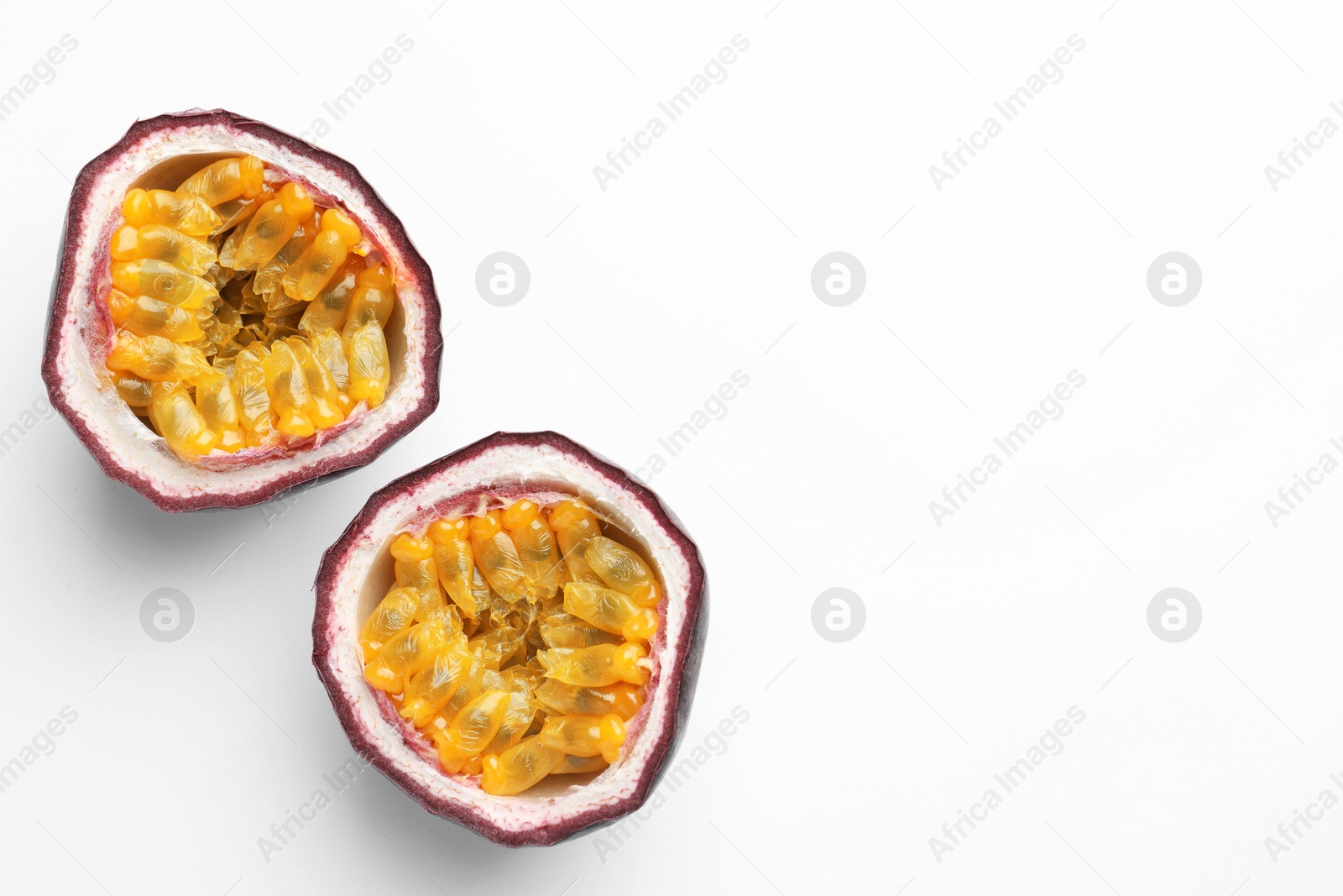 Halves of fresh passion fruit on white background, top view. Space for text Photo of Halves of fresh passion fruit on white background, top view. Space for text