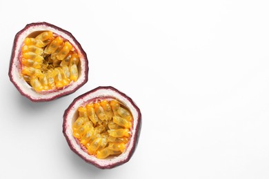 Photo of Halves of fresh passion fruit on white background, top view. Space for text