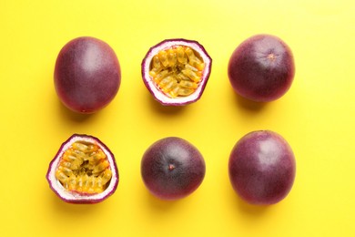 Photo of Fresh passion fruits on yellow background, flat lay. Whole and cut