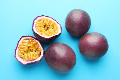 Photo of Fresh passion fruits on light blue background. Whole and cut