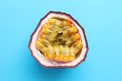 Photo of Half of fresh passion fruit on light blue background, closeup