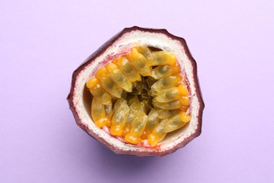 Photo of Half of fresh passion fruit on violet background, closeup