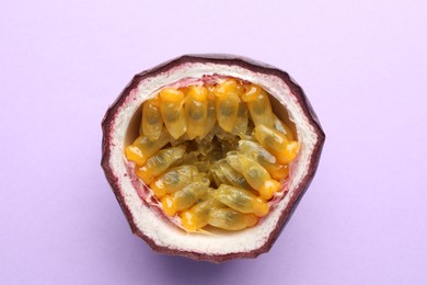 Photo of Half of fresh passion fruit on violet background, closeup