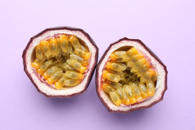 Photo of Halves of fresh passion fruit on violet background, closeup