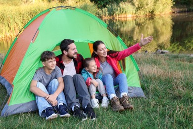 Photo of Happy family spending time together with camping tent outdoors