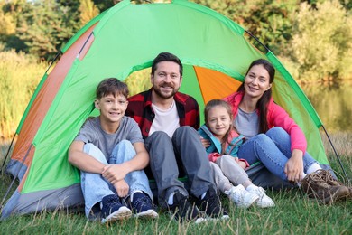 Photo of Happy family spending time together with camping tent outdoors