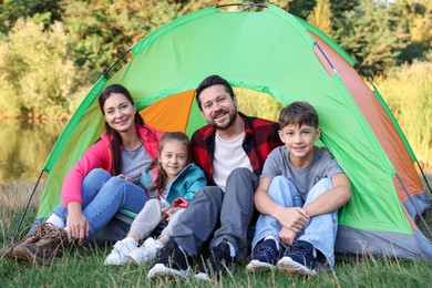 Photo of Happy family spending time together with camping tent outdoors