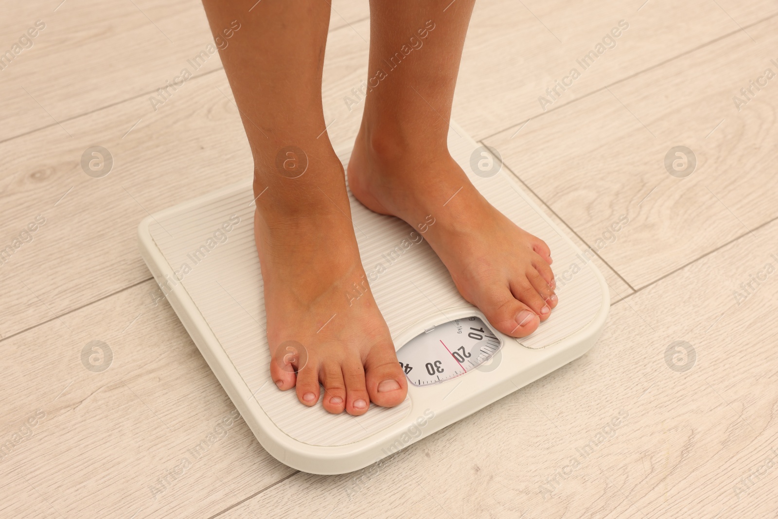 Little boy standing on scales indoors, closeup Photo of Little boy standing on scales indoors, closeup
