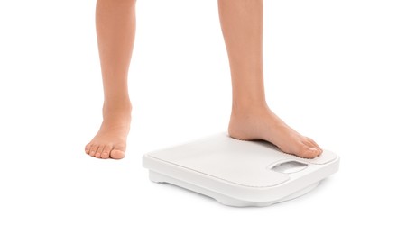 Photo of Little boy standing on scales against white background, closeup