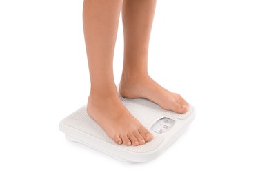 Photo of Little boy standing on scales against white background, closeup