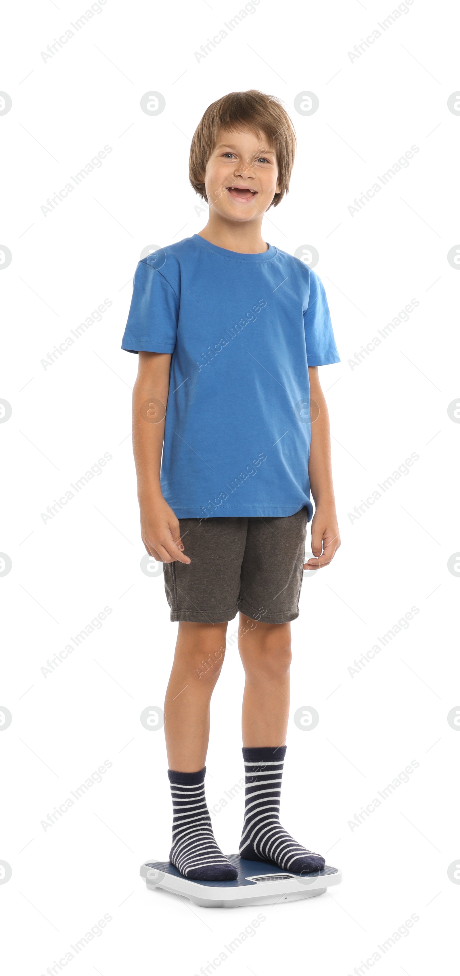 Photo of Little boy standing on scales against white background