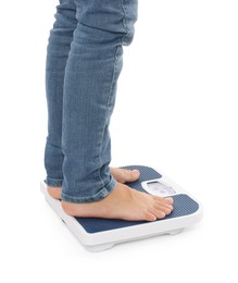 Photo of Little boy standing on scales against white background, closeup