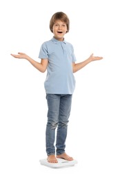 Photo of Little boy standing on scales against white background