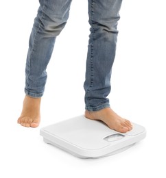 Photo of Little boy standing on scales against white background, closeup