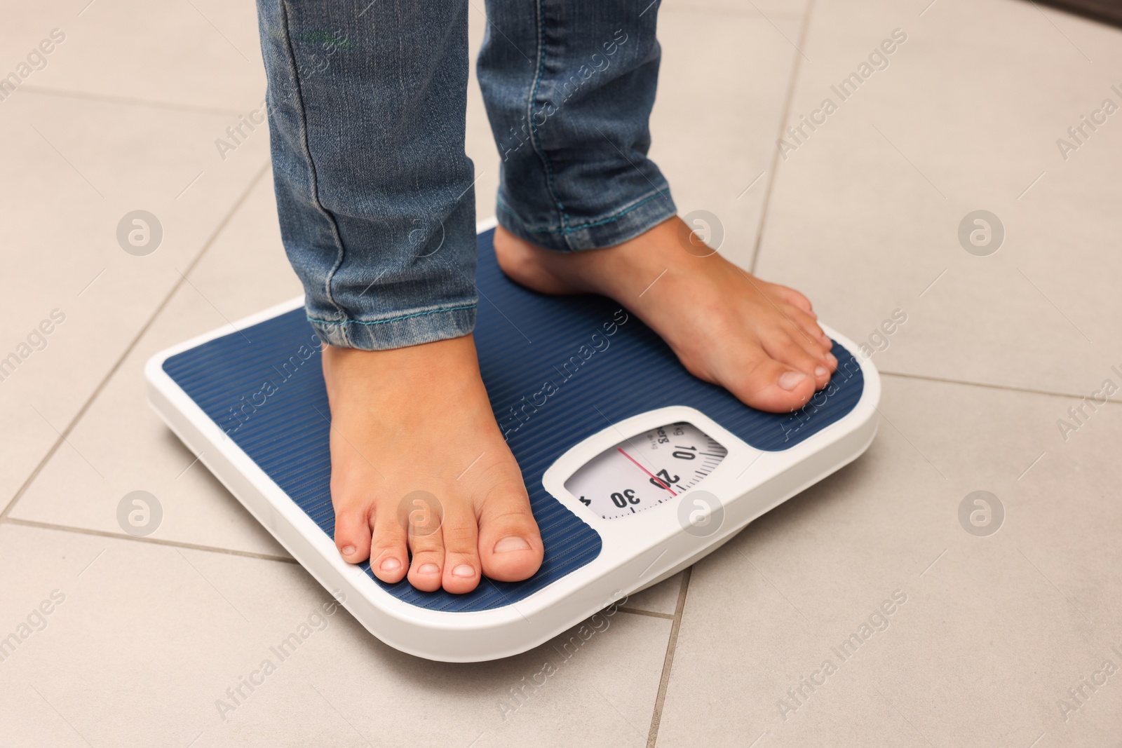 Little boy standing on scales indoors, closeup Photo of Little boy standing on scales indoors, closeup