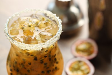 Photo of Tasty passion fruit drink in glass on table, closeup