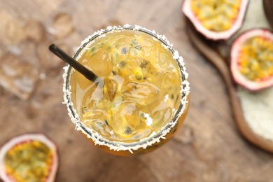 Photo of Tasty passion fruit drink in glass and fresh fruits on table, flat lay