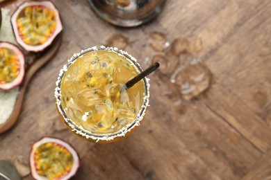 Photo of Tasty passion fruit drink in glass and fresh fruits on table, flat lay. Space for text