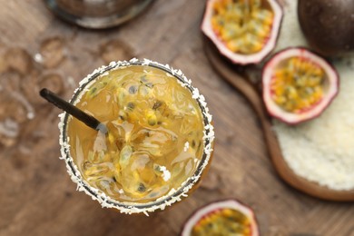 Photo of Tasty passion fruit drink in glass and fresh fruits on table, flat lay