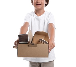 Photo of Recycling. Cute little boy with cardboard box full of different waste paper on white background, closeup