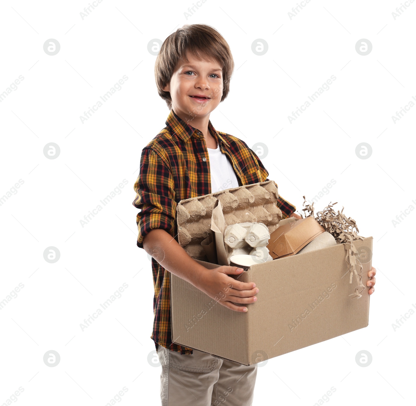 Photo of Recycling. Cute little boy with cardboard box full of different waste paper on white background