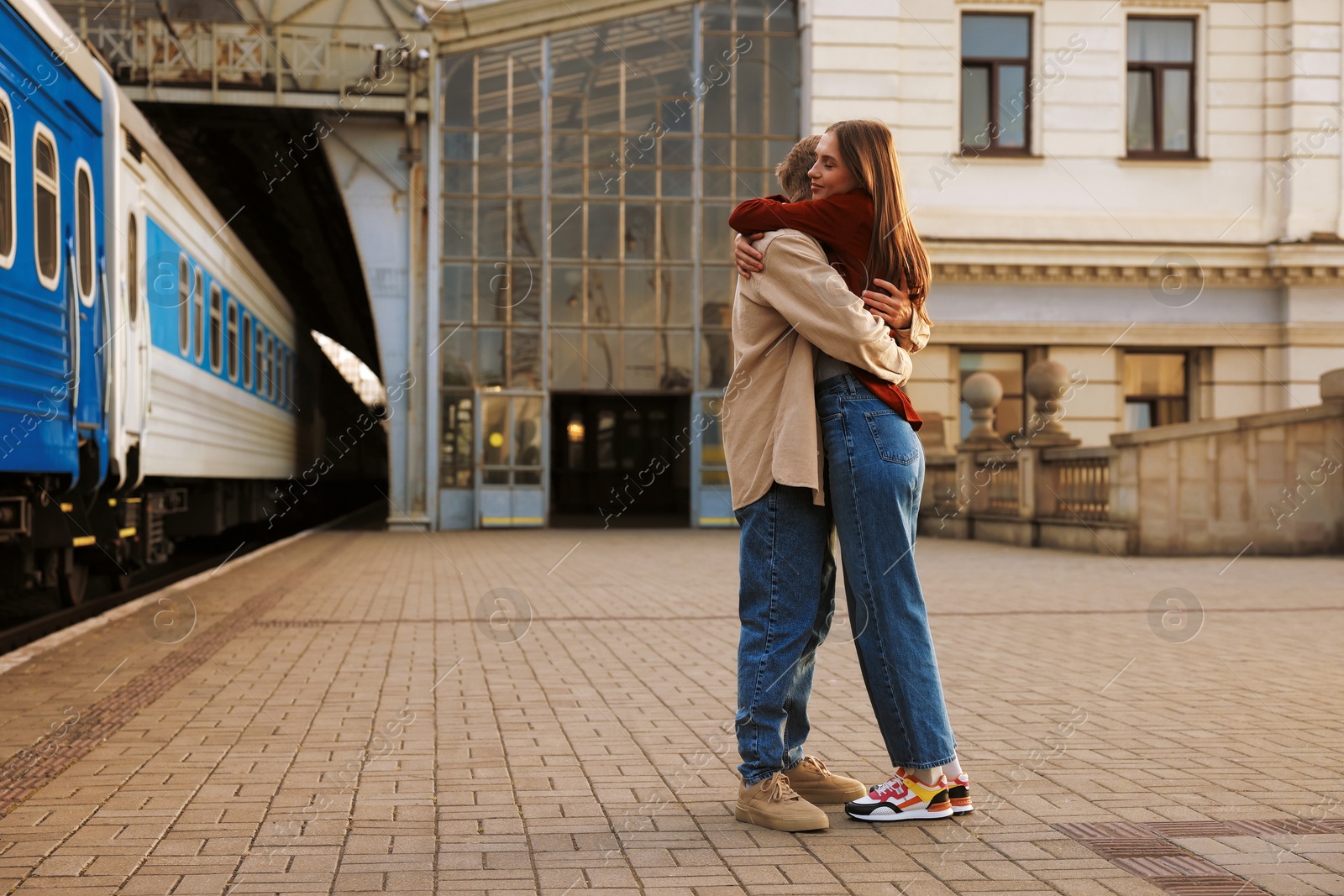 Goodbye. Lovely couple hugging near train outdoors, space for text Photo of Goodbye. Lovely couple hugging near train outdoors, space for text