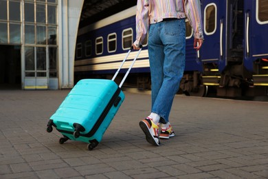 Photo of Goodbye. Woman with luggage on platform of railway station, closeup