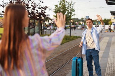 Photo of Goodbye. Woman waving to her boyfriend at bus stop, selective focus