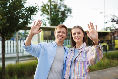 Photo of Goodbye. Lovely couple waving on city street