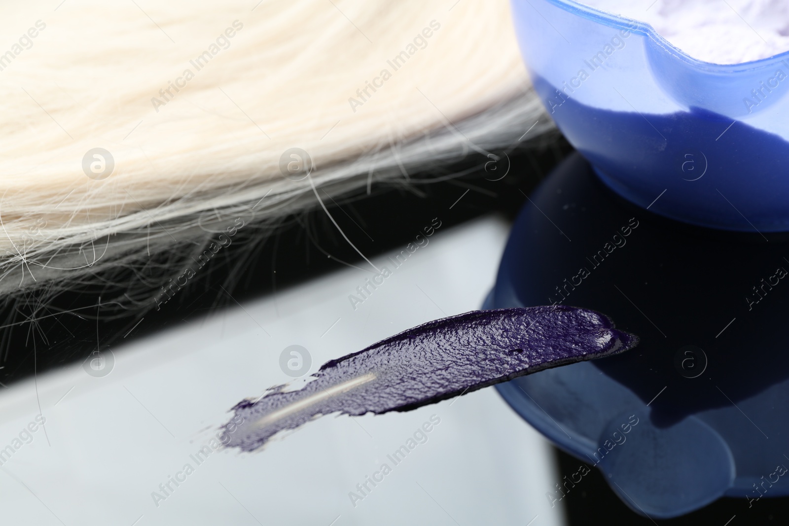 Hair care cosmetic product, blonde hair lock and powder on mirror surface, closeup Photo of Hair care cosmetic product, blonde hair lock and powder on mirror surface, closeup
