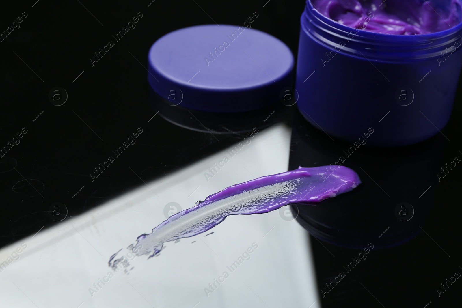 Hair care cosmetic product for blonde hair and jar on mirror surface, closeup Photo of Hair care cosmetic product for blonde hair and jar on mirror surface, closeup