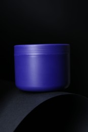 Photo of Jar of hair care cosmetic product for blonde hair on black background