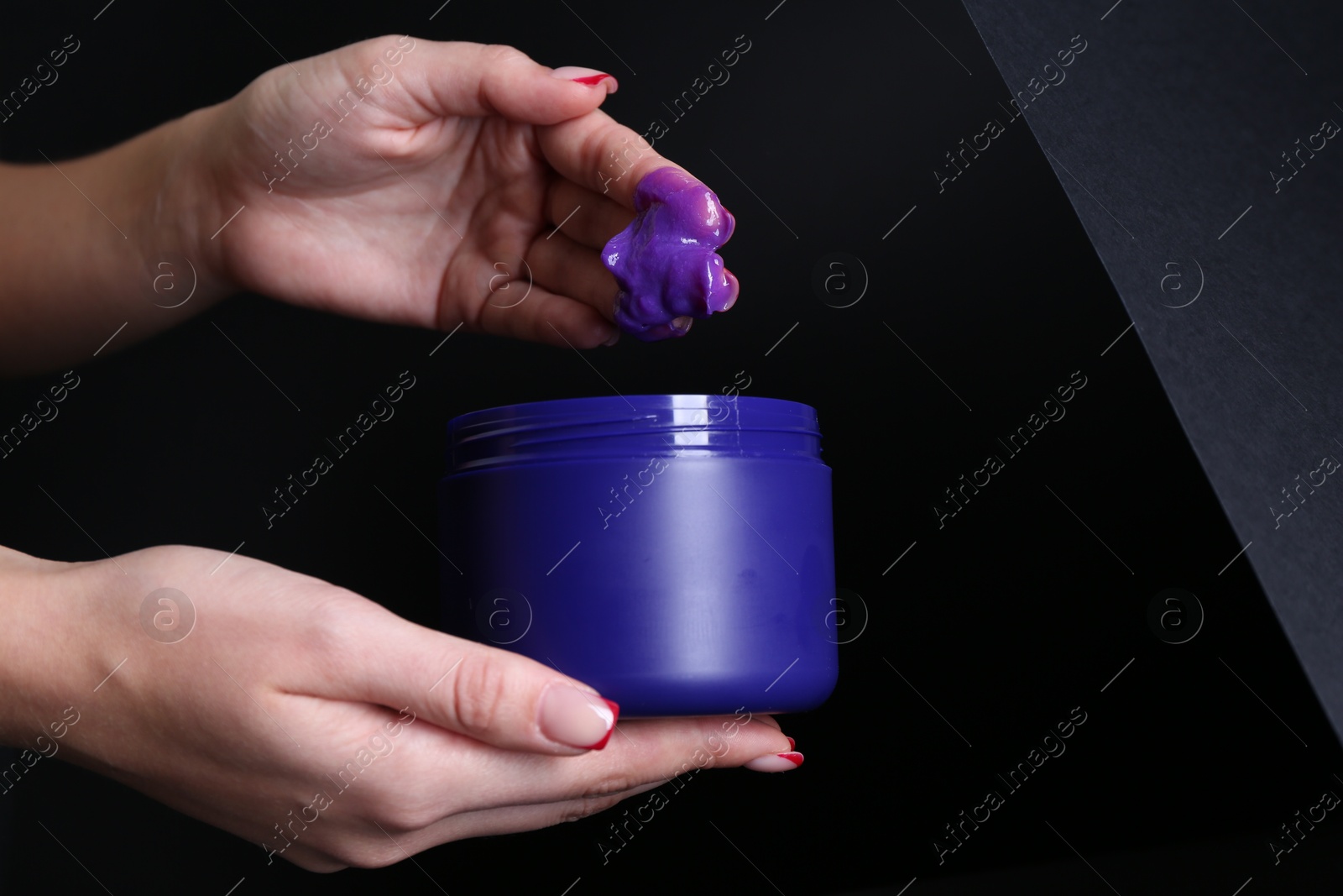 Woman taking hair care cosmetic product for blonde hair against black background, closeup. Space for text Photo of Woman taking hair care cosmetic product for blonde hair against black background, closeup. Space for text